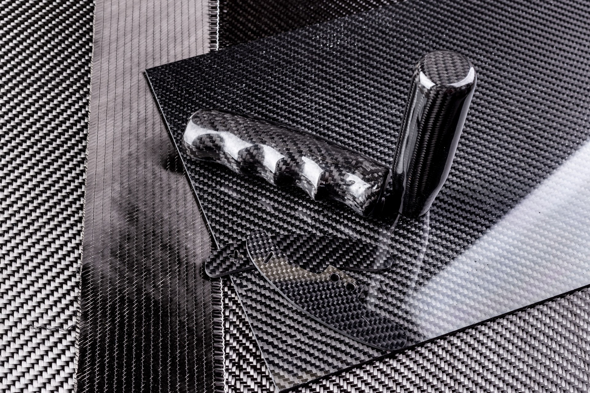Rolls with various real woven carbon fiber enforcement raw material cloth. composite material automotive and car tuning  industry  high tech background.